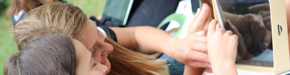 KI generiert: Das Bild zeigt zwei Mädchen, die sich konzentriert ein Tablet ansehen und es bedienen. Es deutet auf eine Nutzung von Technologie im Freien hin.