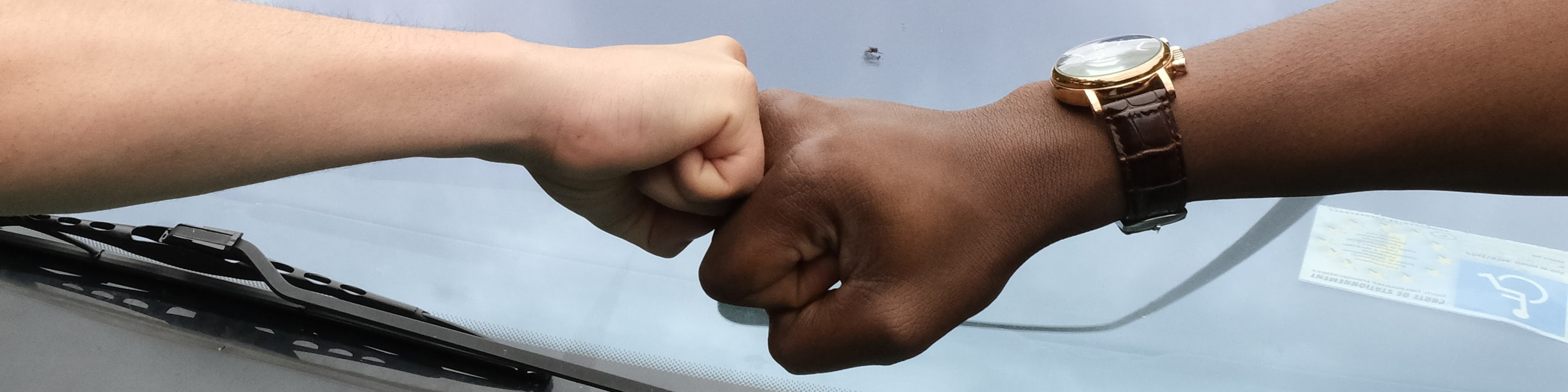 KI generiert: Das Bild zeigt zwei Personen, die sich mit ihren Fäusten begrüßen, wobei eine der Personen eine Armbanduhr trägt. Der Hauptinhalt des Bildes ist der Fauststoß als Geste der Begrüßung oder des Respekts.