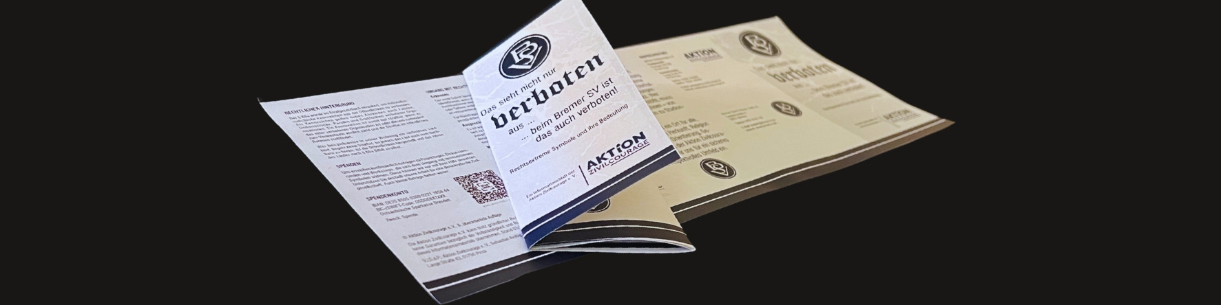KI generiert: Das Bild zeigt zwei offene Broschüren mit dem Titel "verboten" und Informationen zu einem Thema, das nicht vollständig sichtbar ist. Die Broschüren enthalten Text und Grafiken, darunter ein QR-Code und ein Logo der Organisation "Aktion".