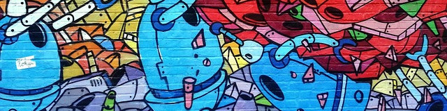 KI generiert: Das Bild zeigt eine bunte Graffiti-Wand mit verschiedenen cartoonartigen Robotern und abstrakten Formen. Der Hauptinhalt sind die beiden prominenten, blau gefärbten Roboterfiguren in der Mitte des Bildes.