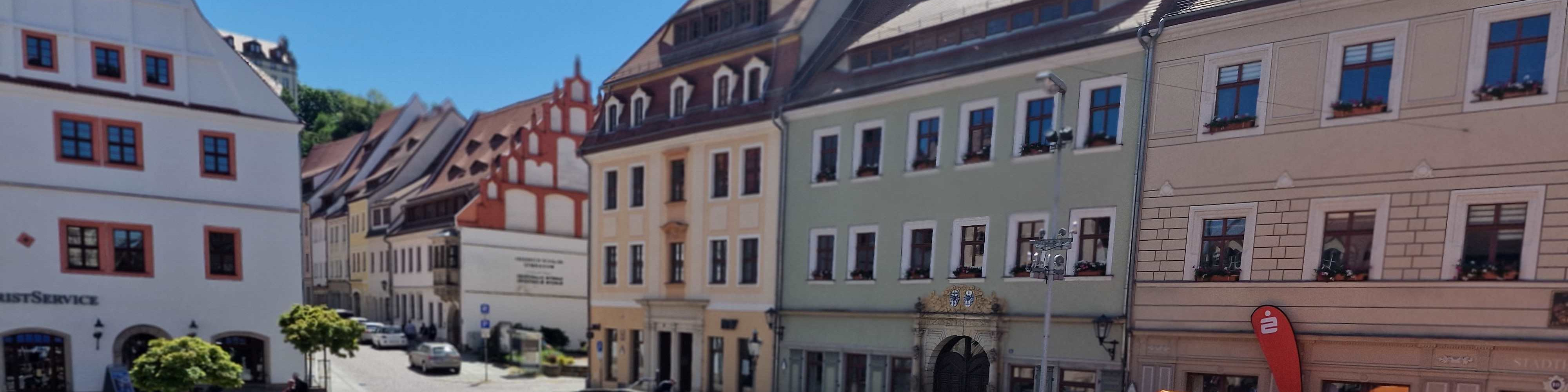 KI generiert: Das Bild zeigt eine malerische Straße in einer europäischen Stadt mit farbenfrohen, historischen Gebäuden und kleinen Läden. Der Hauptinhalt des Bildes sind die traditionellen Häuser und die charmante Atmosphäre der Altstadt.