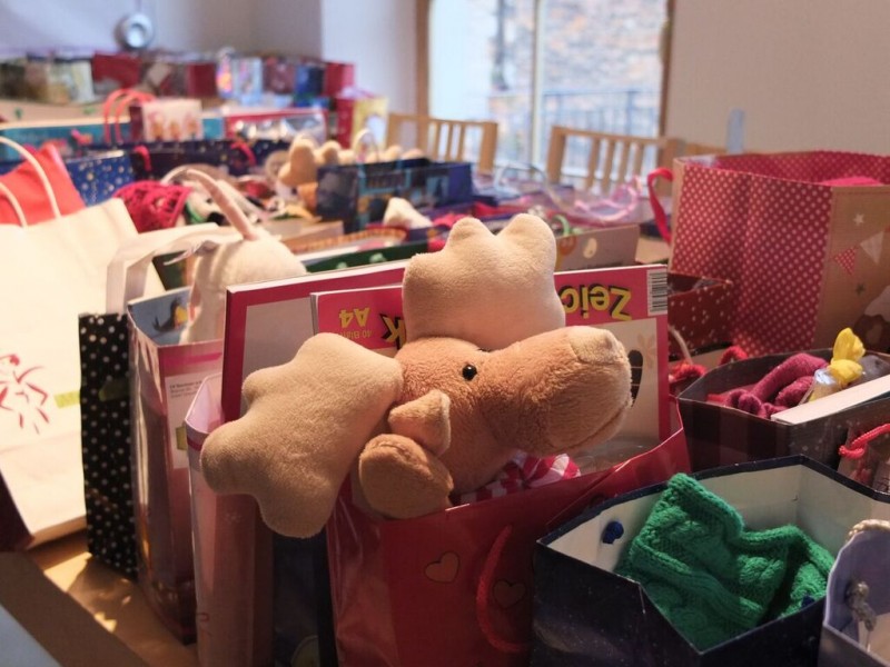 KI generiert: Das Bild zeigt eine Ansammlung von Geschenken, darunter ein großer Stoff-Reindeer, in verschiedenen Geschenkverpackungen. Der Hauptinhalt des Bildes sind die Geschenke, die wahrscheinlich für eine Feier oder ein Fest vorbereitet wurden.