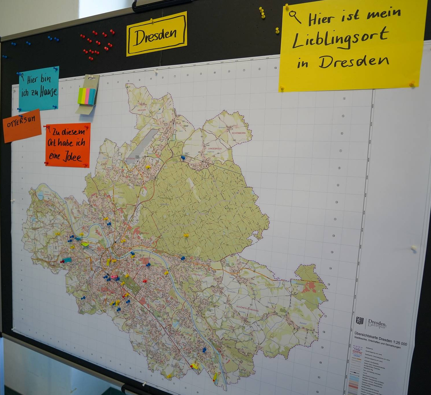 KI generiert: Das Bild zeigt eine große, detaillierte Karte von Dresden mit mehreren farbigen Markierungen und Notizzetteln in deutscher Sprache, die verschiedene Orte und persönliche Notizen kennzeichnen. Der Hauptinhalt ist die Darstellung der Stadt Dresden mit individuellen Anmerkungen zu bestimmten Orten.