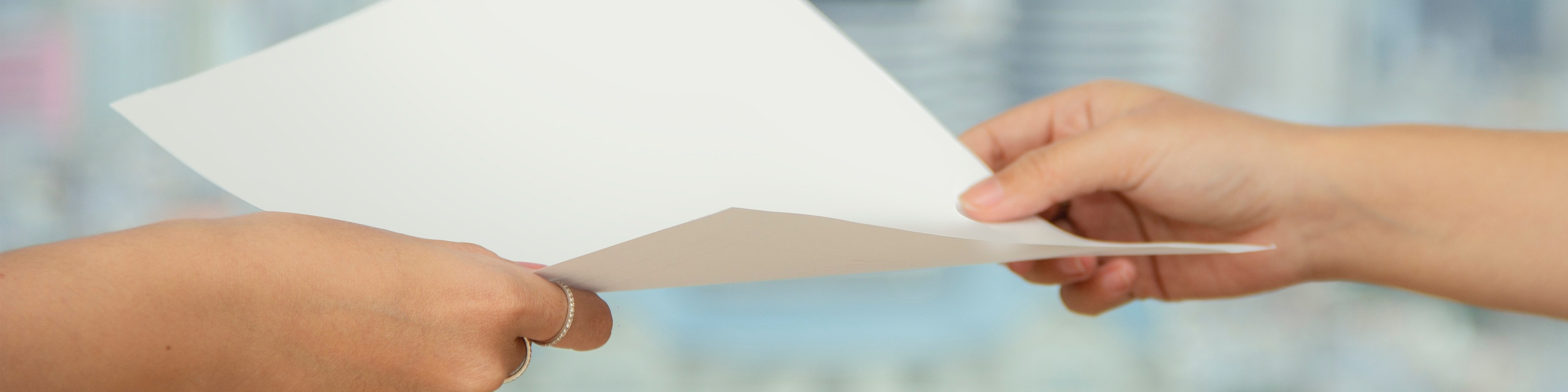 KI generiert: Das Bild zeigt zwei Hände, die sich ein weißes Blatt Papier reichen. Der Hauptinhalt des Bildes ist die Übergabe oder der Austausch eines Dokuments.