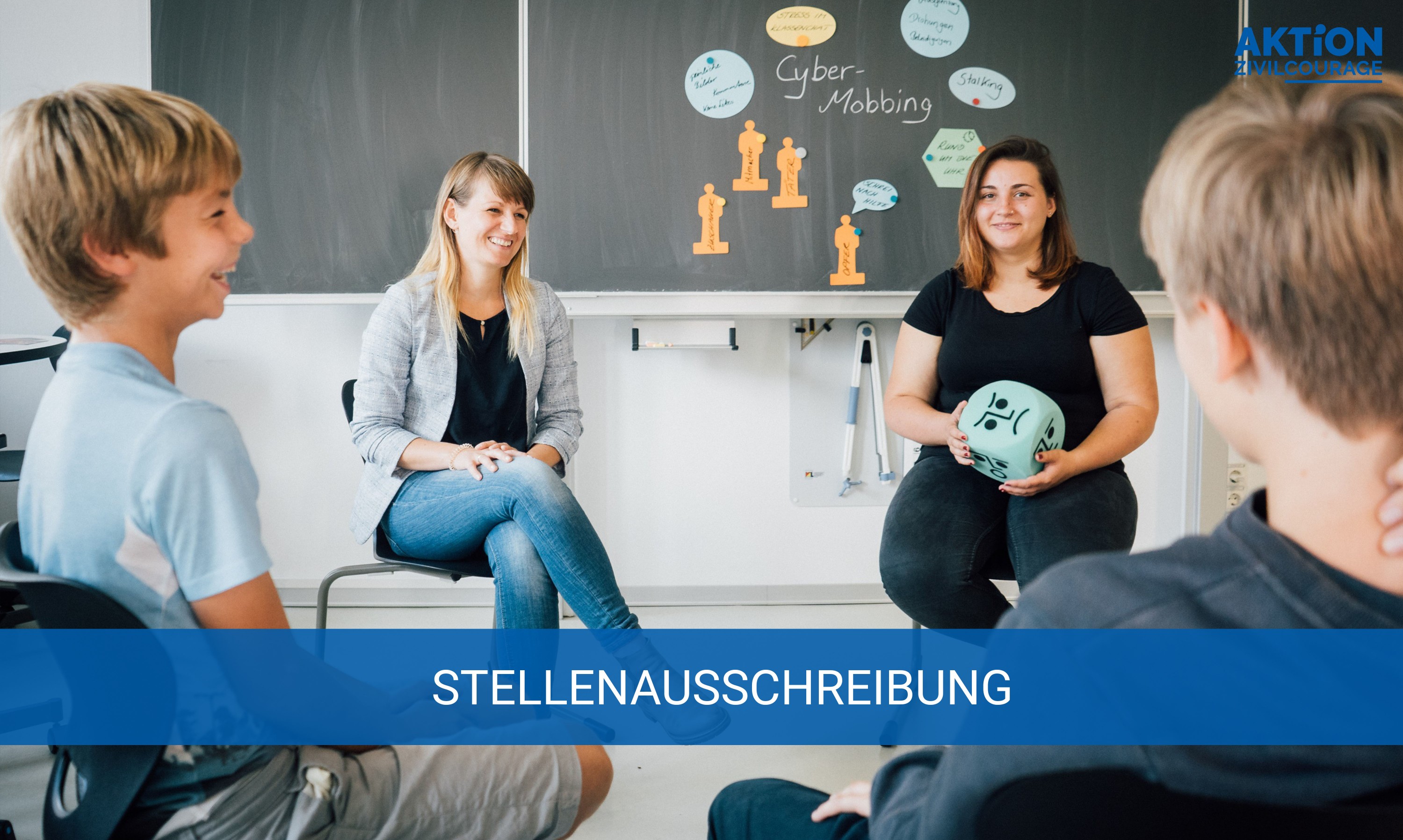KI generiert: Das Bild zeigt eine Gruppe von Personen, darunter zwei Frauen und zwei Jugendliche, die in einem Klassenzimmer sitzen und sich unterhalten. Im Hintergrund ist eine Tafel mit Notizen und Zeichnungen zum Thema "Cyber-Mobbing" zu sehen. Der Hauptinhalt des Bildes ist eine Diskussion oder ein Workshop zum Thema Cyber-Mobbing.