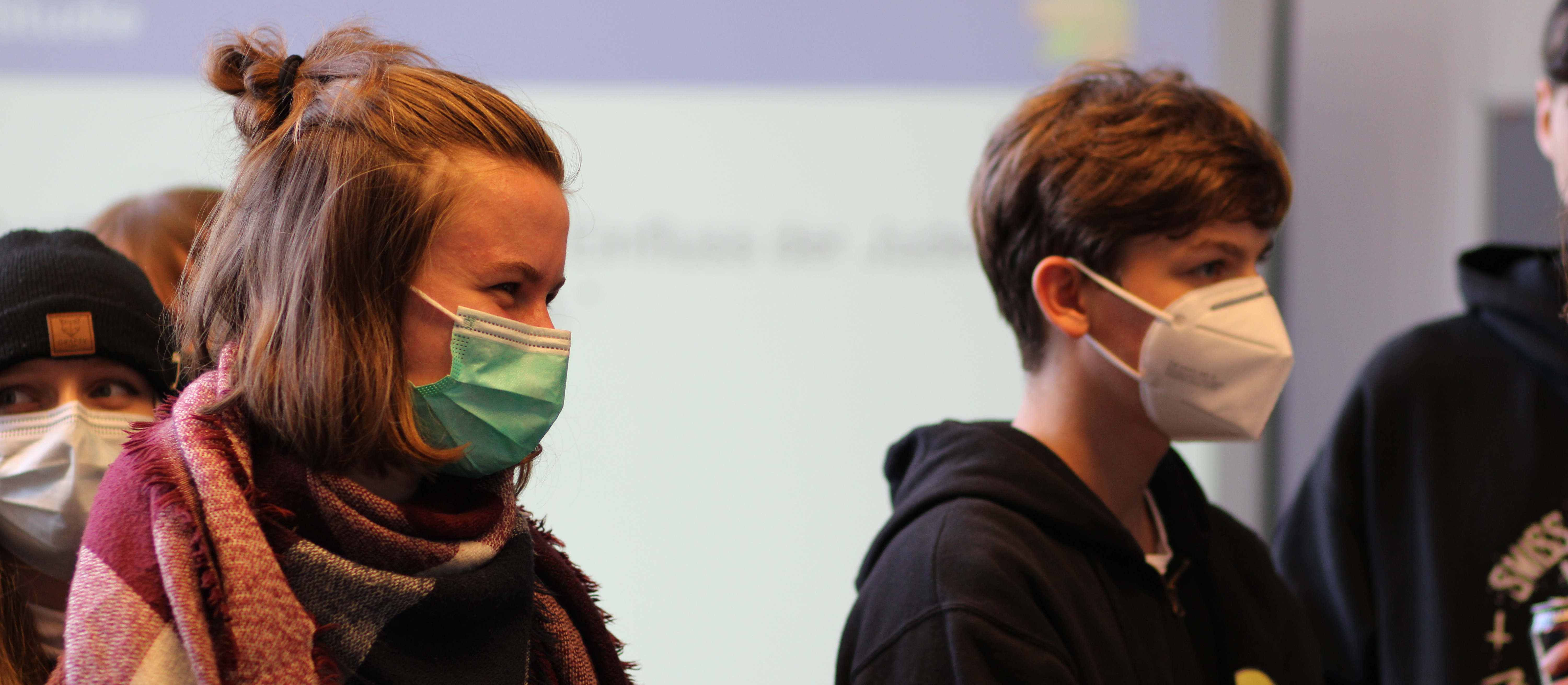 KI generiert: Das Bild zeigt eine Gruppe von Personen, die alle Gesichtsmasken tragen, in einem Innenraum. Der Hauptinhalt des Bildes ist die Darstellung von Menschen, die sich an die Maskenpflicht halten, möglicherweise während der COVID-19-Pandemie.