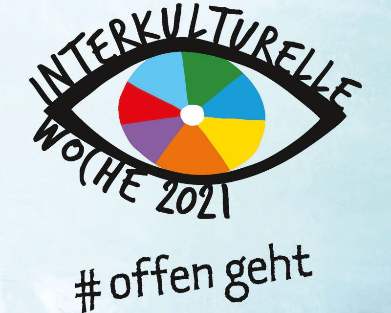 KI generiert: Das Bild zeigt ein stilisiertes Auge mit einer bunten Iris, die wie ein Farbkreis in den Regenbogenfarben gestaltet ist. Über dem Auge steht "INTERKULTURELLE WOCHE 2021" und darunter der Hashtag "#offen geht".