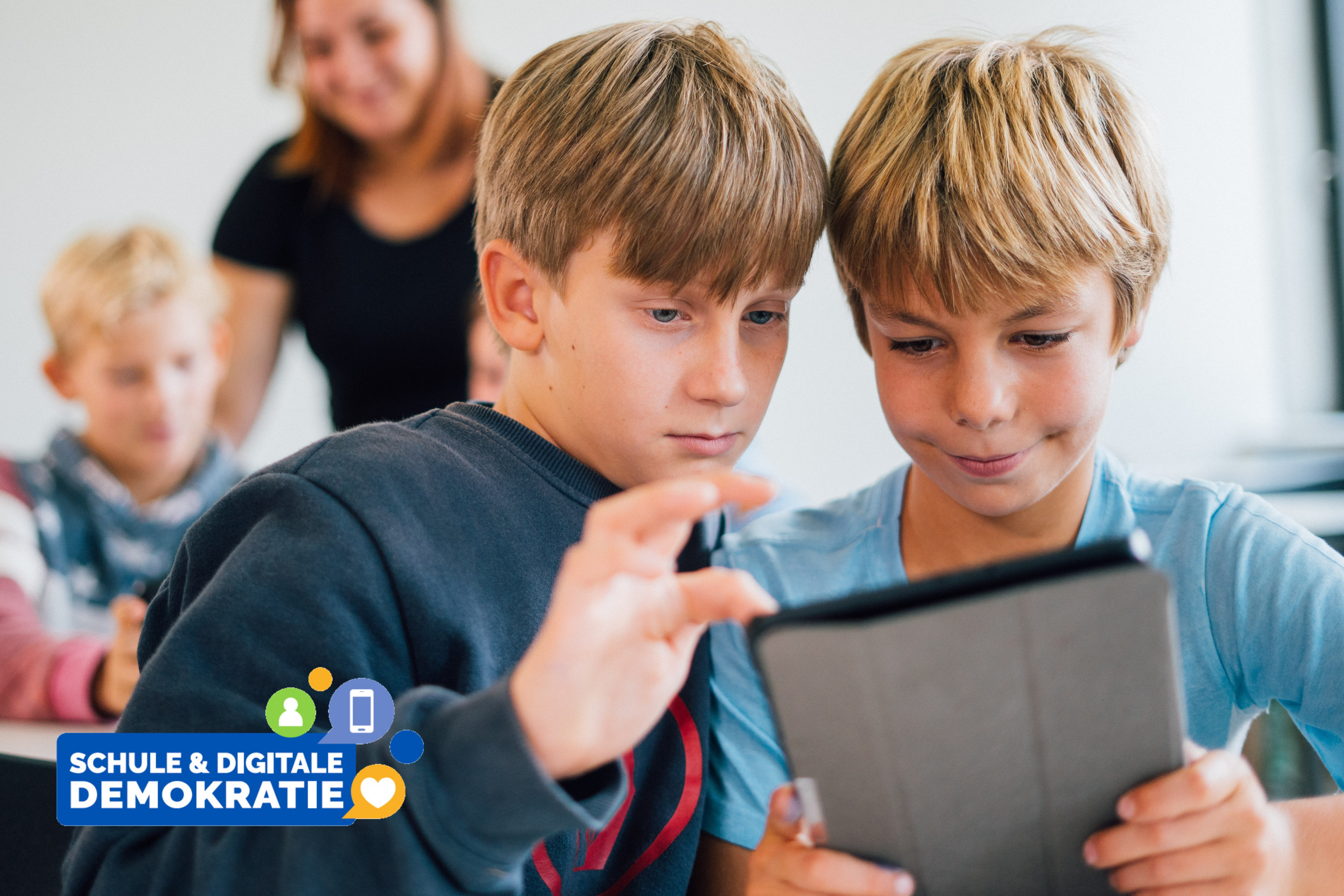 KI generiert: Das Bild zeigt zwei Jungen, die gemeinsam auf ein Tablet schauen, während sie in einer Gruppe mit anderen Kindern und einer erwachsenen Person im Hintergrund sind. Der Hauptinhalt des Bildes ist die Interaktion der Kinder mit digitalen Medien, was durch den Text "Schule & digitale Demokratie" betont wird.