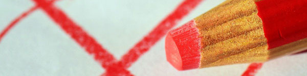 KI generiert: Das Bild zeigt einen roten Stift, der auf einem Blatt Papier liegt, auf dem ein großes rotes Kreuz gemalt ist. Der Hauptinhalt des Bildes ist der rote Stift und das Kreuz.