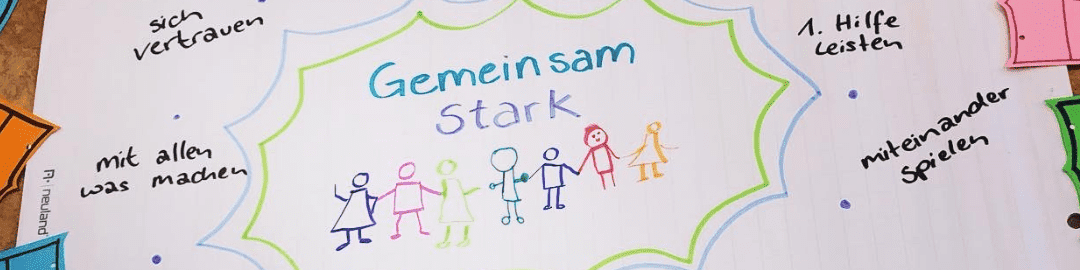 KI generiert: Das Bild zeigt eine bunte Zeichnung mit dem Titel "Gemeinsam Stark" in der Mitte, umgeben von einfachen Figuren, die sich an den Händen halten. Um die Zeichnung herum stehen Sätze wie "sich vertrauen", "mit allen was machen" und "miteinander spielen", die Gemeinschaft und Zusammenarbeit betonen.