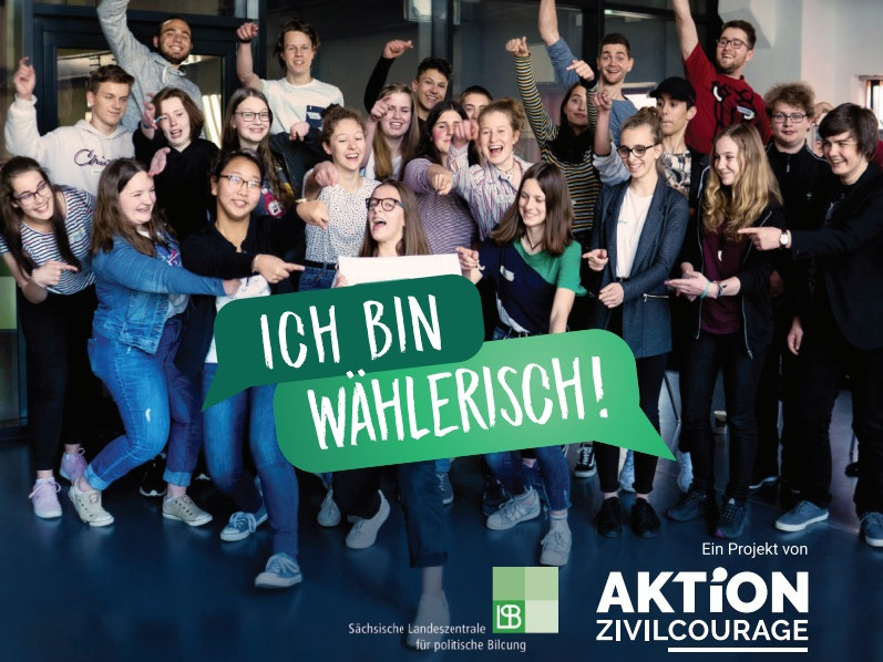 KI generiert: Das Bild zeigt eine Gruppe von Schülern in einem Klassenzimmer, wobei zwei Schüler im Vordergrund posieren und ein Text "ICH BIN WÄHLERISCH!" eingeblendet ist. Der Hauptinhalt des Bildes ist die Förderung der Wahlbeteiligung, insbesondere bei jungen Menschen.