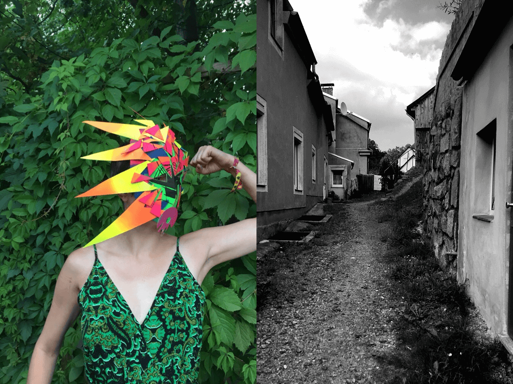 KI generiert: Das Bild zeigt eine Person mit einem farbenfrohen, geometrischen Maskenkostüm, die in einer grünen Umgebung steht, während der Hintergrund eine schmale Gasse mit Häusern in Schwarz-Weiß zeigt. Der Hauptinhalt des Bildes ist der Kontrast zwischen der lebendigen, farbigen Maske und der sonst monochromen Umgebung.