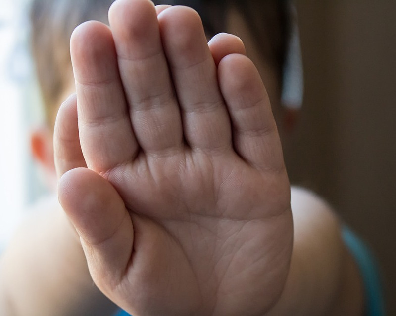 KI generiert: Das Bild zeigt drei Kinder im Freien, die sich unterhalten oder interagieren, wobei eines der Kinder lachend in die Kamera schaut. Der Hauptinhalt des Bildes ist die fröhliche und spielerische Atmosphäre zwischen den Kindern in einer natürlichen Umgebung.