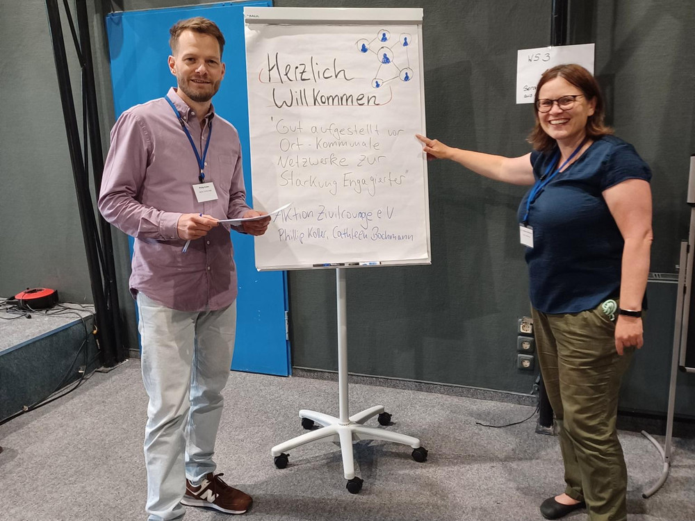 KI generiert: Das Bild zeigt eine Präsentation oder einen Vortrag in einem Seminarraum, bei dem ein Mann vor einem Publikum spricht und eine PowerPoint-Präsentation auf einer Leinwand im Hintergrund zu sehen ist. Der Hauptinhalt des Bildes ist die Darstellung einer Bildungs- oder Informationsveranstaltung.