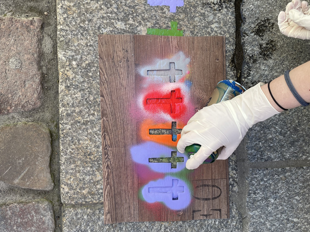 KI generiert: Das Bild zeigt einen gepflasterten Boden mit farbigen Pfeilen und Markierungen in Gelb und Pink. Die Pfeile und Markierungen scheinen als Wegweiser oder Hinweise zu dienen.