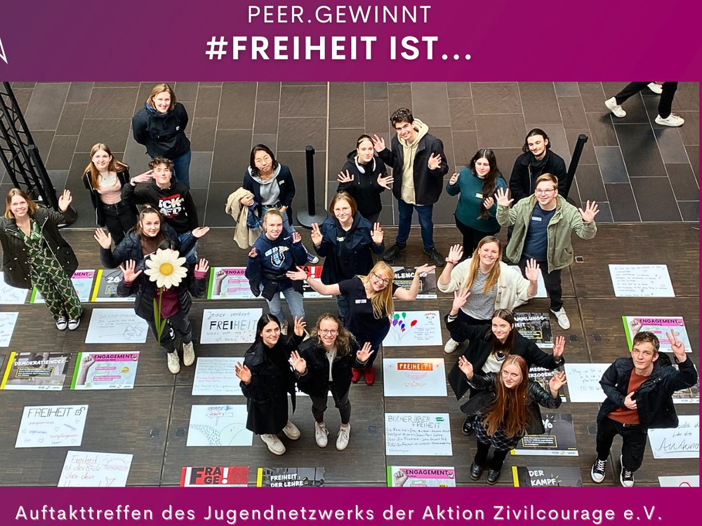 KI generiert: Das Bild zeigt eine Wand mit vielen kleinen, an Pinnwänden befestigten Zetteln oder Karten, die in einem strukturierten Raster angeordnet sind. Im Vordergrund sind Regale mit verschiedenen Gegenständen zu sehen, darunter bunte Kabel und technische Ausrüstung.