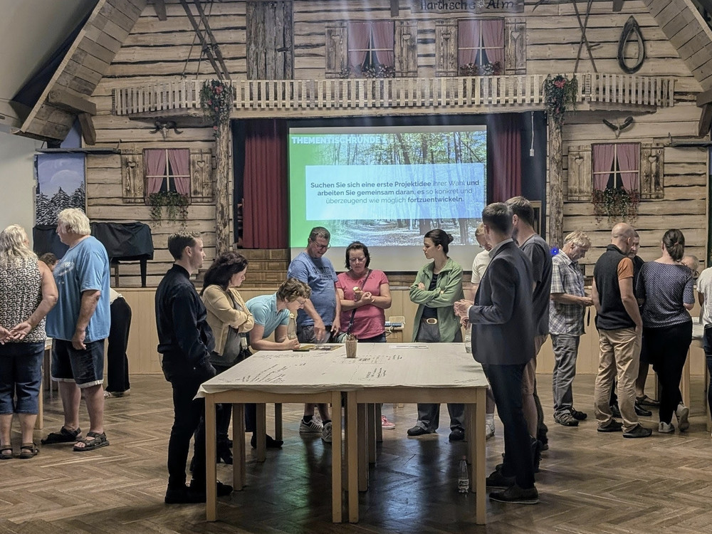 KI generiert: Das Bild zeigt zwei Gruppen von Personen, die jeweils vor unterschiedlichen Hintergründen posieren. Die linke Gruppe steht vor einer rustikalen Holzwand, während die rechte Gruppe vor einer Leinwand mit einer Präsentation steht.