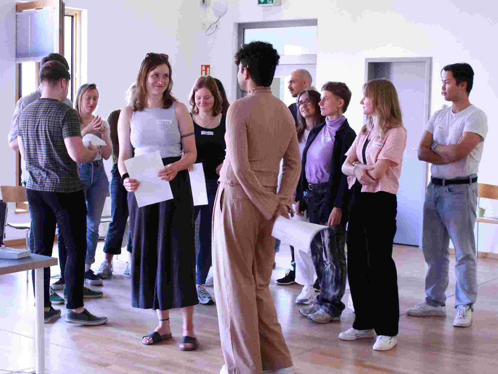 KI generiert: Das Bild zeigt eine Gruppe von Personen in einem Seminarraum, wobei eine Person vorne steht und eine Präsentation hält. Der Hauptinhalt des Bildes ist eine Bildungs- oder Schulungsveranstaltung.