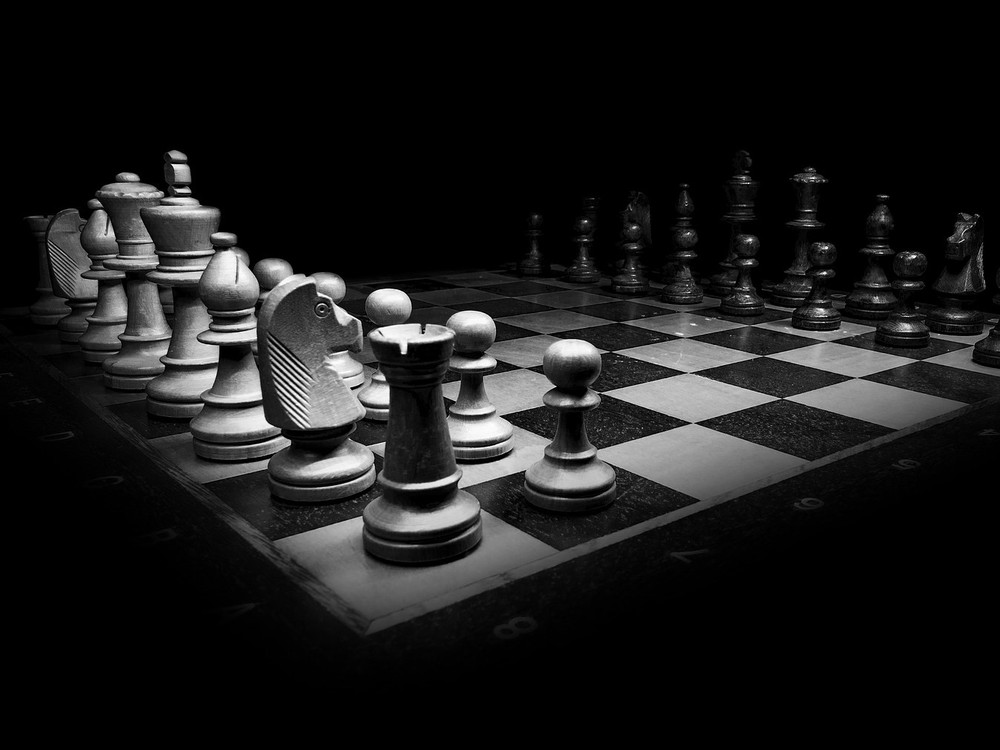 KI generiert: Das Bild zeigt ein Schachbrett mit aufgestellten Schachfiguren, die sich in einer Spielposition befinden. Der Hauptinhalt des Bildes ist das Schachspiel, das durch die Anordnung der Figuren auf dem Brett dargestellt wird.