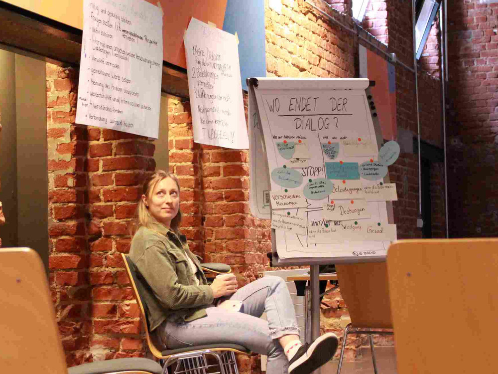 KI generiert: Das Bild zeigt eine Person, die an einem Tisch sitzt und auf einem Blatt Papier Notizen macht. Der Hauptinhalt des Bildes sind die handschriftlichen Notizen auf dem Papier, die sich auf das Thema "Compact Magazin" beziehen.