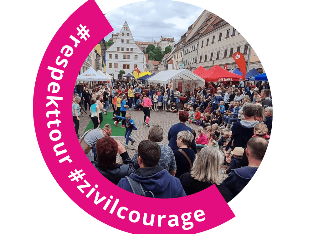 KI generiert: Das Bild zeigt eine belebte Straßenveranstaltung mit vielen Menschen, die eine Performance auf einer kleinen Bühne beobachten. Im Vordergrund ist ein pinkfarbener Kreis mit den Hashtags #respektour und #zivilcourage zu sehen.