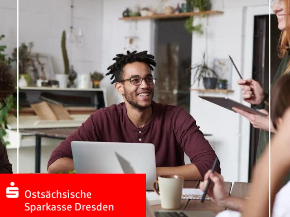 KI generiert: Das Bild zeigt eine Gruppe von Personen, die in einem modernen Büro oder Co-Working-Space zusammenarbeiten. Eine Person im Vordergrund arbeitet an einem Laptop, während andere im Hintergrund diskutieren und Notizen machen.