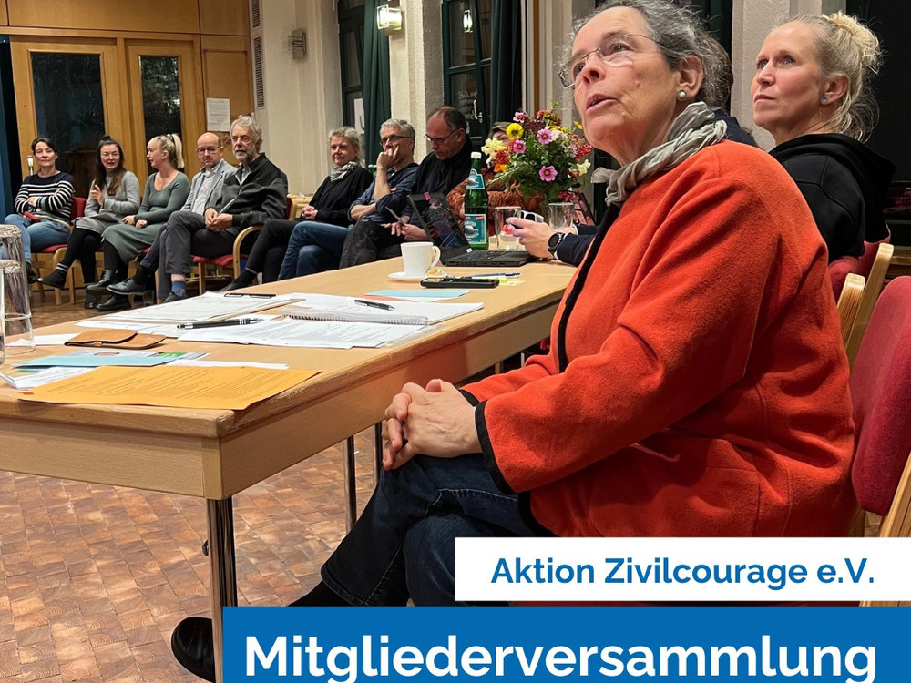 KI generiert: Das Bild zeigt eine Gruppe von Personen in einem Raum, die ihre Hände mit blauen Karten hochhalten. Es scheint sich um eine Abstimmung oder eine Wahl zu handeln.
