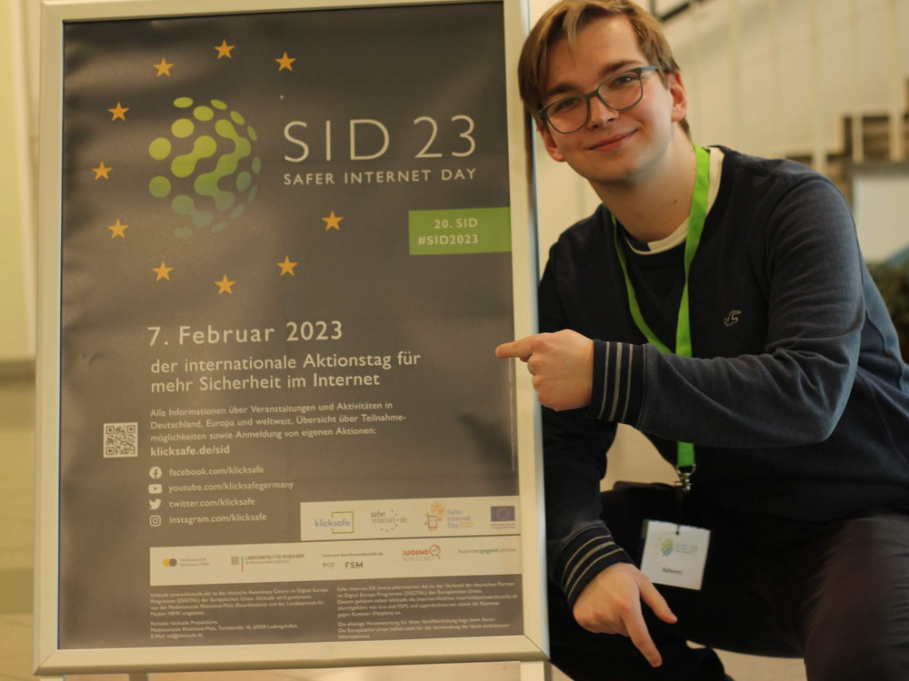 KI generiert: Das Bild zeigt das Logo für den Safer Internet Day 2023 (SID 23). Es besteht aus einem stilisierten, bunten Globus, umgeben von drei gelben Sternen, sowie der Text "SID 23" und "SAFER INTERNET DAY".