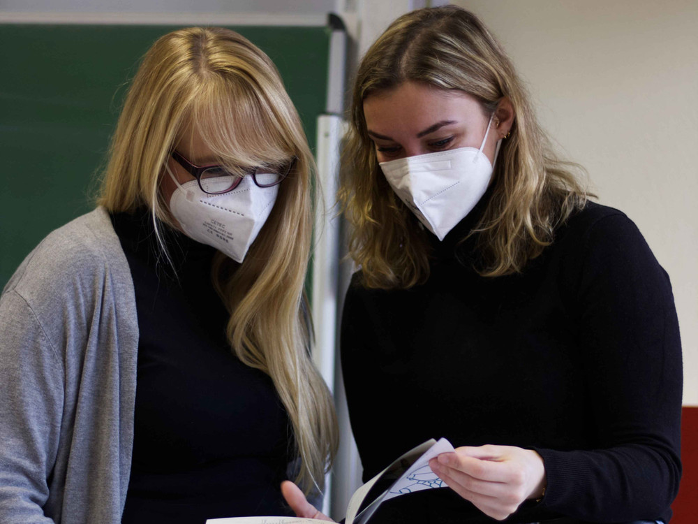 KI generiert: Das Bild zeigt einen Mann mit einem dunklen Hut und einer Jacke, der sich leicht nach vorne beugt. Der Hauptinhalt des Bildes ist das Porträt des Mannes, der in einer scheinbar natürlichen Umgebung steht.